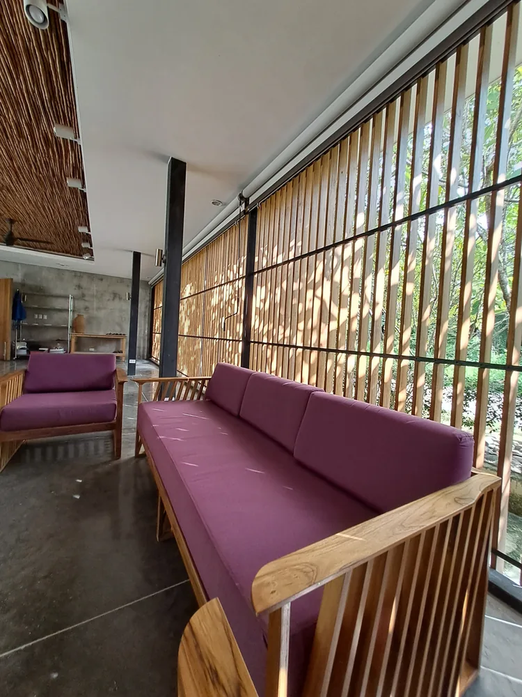The Klei lounge with purple sofas and sunlight through the wooden slats